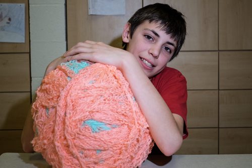 Adrien Wall, 11, with his ball of finger knitted yarn. He plans on knitting 4 miles of the stuff in an effort to break a world record. At the moment his ball holds about 1300 feet of finger knitted yarn. Elaine Owen, a teacher at Miami School in Miami, Manitoba has undertaken a huge project to teach her students some core values. Over the last six months, she has gathered raw wool and shown her students the process through washing, carding, dyeing and spinning the wool and then using looms, making mittens, scarves, etc. Elaine has four spinning wheels in her classroom and the students are donating their crafted items to a local shelter.  150113 - Wednesday, January 14, 2015 -  (MIKE DEAL / WINNIPEG FREE PRESS)
