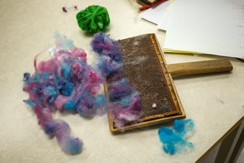 Dyed wool sits on a students desk waiting to be carded so that it can be spun into yarn. Elaine Owen, a teacher at Miami School in Miami, Manitoba has undertaken a huge project to teach her students some core values. Over the last six months, she has gathered raw wool and shown her students the process through washing, carding, dyeing and spinning the wool and then using looms, making mittens, scarves, etc. Elaine has four spinning wheels in her classroom and the students are donating their crafted items to a local shelter.  150113 - Wednesday, January 14, 2015 -  (MIKE DEAL / WINNIPEG FREE PRESS)