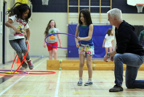 Windsor School grade 3 students Kaleigh Smith and Donya Naghibzad work with Dean Kriellaars, a University of Manitoba exercise physiologist who also works with Cirque de Soleil performers. He is working on a preliminary study with a Montreal-based researcher from the National Circus School. He is at Windsor School to find out how kids respond to creative circus-inspired movement. BORIS MINKEVICH/WINNIPEG FREE PRESS. JANUARY 15, 2015