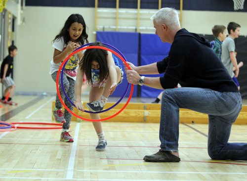 Windsor School grade 3 students Kaleigh Smith and Donya Naghibzad work with Dean Kriellaars, a University of Manitoba exercise physiologist who also works with Cirque de Soleil performers. He is working on a preliminary study with a Montreal-based researcher from the National Circus School. He is at Windsor School to find out how kids respond to creative circus-inspired movement. BORIS MINKEVICH/WINNIPEG FREE PRESS. JANUARY 15, 2015