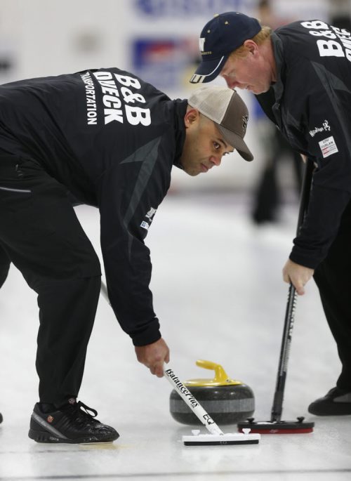 Lead Stan Pierre at left and second Craig Nichol  sweep a rock in a game at the Assiniboine Memorial CC Friday.  Ed Tait story  Wayne Glowacki / Winnipeg Free Press ¤Jan. 16 2015