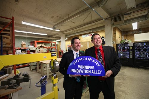 Winnipeg Mayor Brian Bowman and Michael Legary with Startup Winnipeg, hold new sign entittled  "Honourary Winnipeg Innovation Ally"  that was put on top of the  Adelaide St. and Bannatyne Ave. Sign at unveiling Friday.   See Story.  Jan 16, 2015 Ruth Bonneville / Winnipeg Free Press