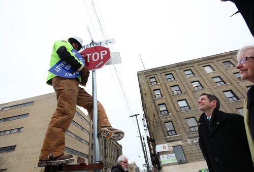 A city of Winnipeg worker puts up and new sign entittled "Honourary Winnipeg Innovation Ally"  on top of the Adelaide St. and Bannatyne Ave. Sign Friday afternoon Mayor Brian Bowman and MP Joy Smith look on after official unveiling at Startup Winnipeg.   See Story.   Jan 16, 2015 Ruth Bonneville / Winnipeg Free Press