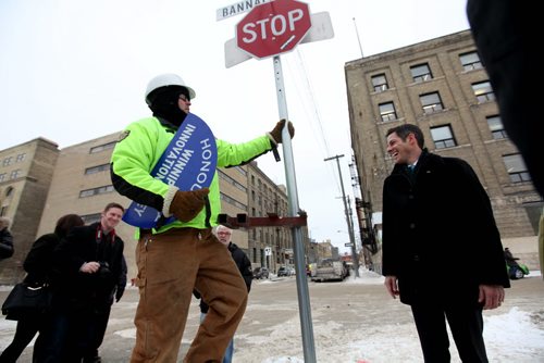 A city of Winnipeg worker puts up and new sign Friday entittled "Honourary Winnipeg Innovation Ally"  on top of the Adelaide St. and Bannatyne Ave. Sign as Wpg Mayor Brian Bowman looks on.   See Story.   Jan 16, 2015 Ruth Bonneville / Winnipeg Free Press