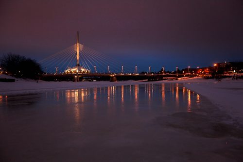The lights of the Esplanade Bridge reflected in the ice along the River Trail on the Red River as a pink hue filled the skies at dusk Saturday evening.   Standup photo  Jan 17, 2015 Ruth Bonneville / Winnipeg Free Press