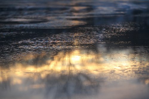 The yellow and orange hue of the setting sun reflects in the puddles and ice crystals  along the River Trail on the Red River at dusk Saturday evening.   Standup photo  Jan 17, 2015 Ruth Bonneville / Winnipeg Free Press