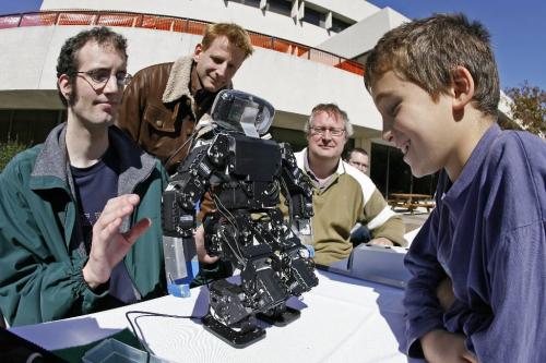 John Woods / Winnipeg Free Press / September 15/07- 070915  - Israel Kahane (9) reacts as Computer Science student Mike De-Denus (L) and professors John Anderson (C) and Jacky Baltes (R) show off their robot at the University of Manitoba Open House Saturday September 15/07.  Computer Science student Brian McKinnon looks on in the background.