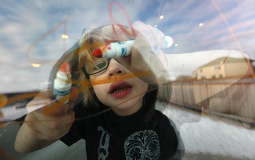 Four yr old Cian Anaka drawing on the family room window with his markers Monday. See Mary Agnes story re: Child Care. January 19, 2015 - (Phil Hossack / Winipeg Free Press)