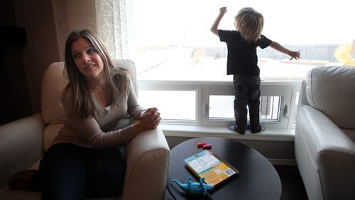 Four yr old Cian Anaka drawing on the family room window with his markers Monday. Mom Kristi sits keeping an eye on things. See Mary Agnes story re: Child Care. January 19, 2015 - (Phil Hossack / Winipeg Free Press)