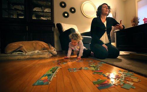 Playing in the living room floor, Two and a half yr old Vera stays close to mom Jamie Slight and the family greyhound Monday. See Mary Agnes story re: Child Care. January 19, 2015 - (Phil Hossack / Winipeg Free Press)