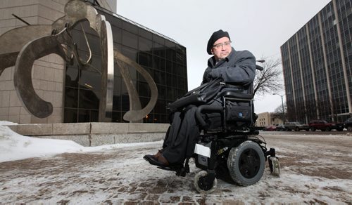Lawyer Peter Tonge poses in front of the Law Courts building with his rented power chair that he pays for while he waits for his to be fixed. See Carol Sanders story.   Jan 20 / 2014  Ruth Bonneville / Winnipeg Free Press.