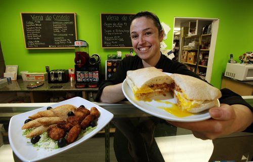 Owner Ana Godinho Esteves poses with a platter of turnovers filled with either tuna, codfish or shrimp and codfish cakes (left) and a Chourico bun w/fried egg at the Viena do Castelo. See Marion's Review. January 20, 2015 - (Phil Hossack / Winnipeg Free Press)