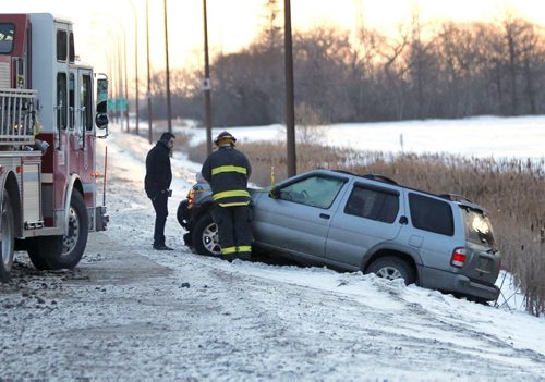 LOCAL -STANDUP - Emergency crews tend to a SUV that slid off the road into the ditch on Furmor near Beaverbrook in Southdale. Road conditions are greasy despite clear skies this morning. BORIS MINKEVICH/WINNIPEG FREE PRESS. JANUARY 21, 2015