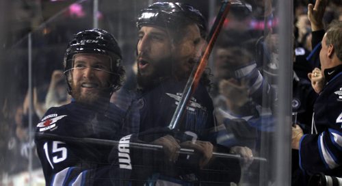 Winnipeg Jets Matt Halischuk (left) and Chris Thorburn embrace after Thorburn scored the Jet's 4th Goal in the second period off an assist from Halischuk. at the MTS Center Wednesday.  January 21, 2015 - (Phil Hossack / Winnipeg Free Press)