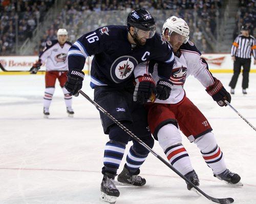 Winnipeg Jets  Captain Andrew Ladd takes out Columbus Blue Jacket #21 James Wisniewski in 2nd period action at the MTS Center Wednesday.  Ladd drew a 2 minute minor on the play. January 21, 2015 - (Phil Hossack / Winnipeg Free Press)