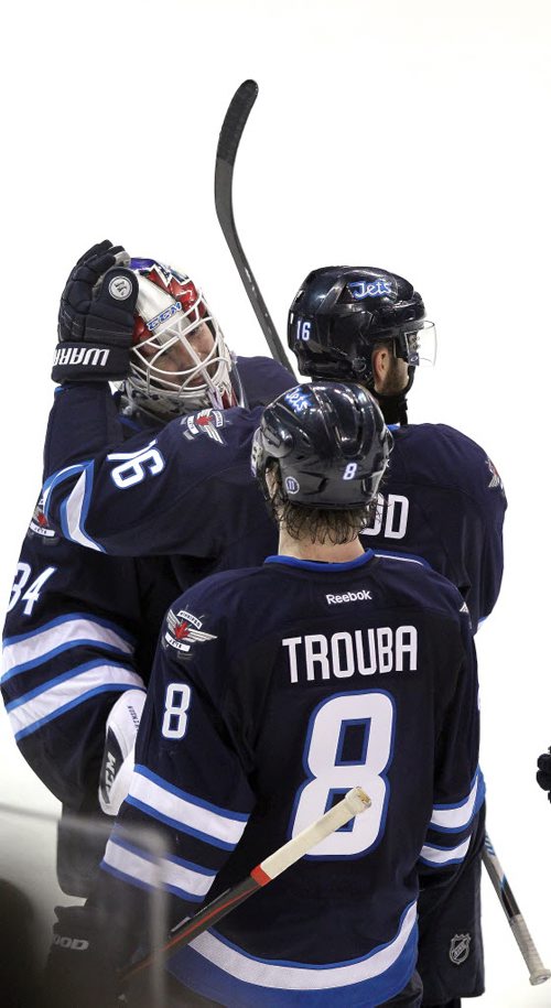 Winnipeg Jets netminder Michael Hutchinson gets congrats from team captain Andrew Ladd and Jacob Trouba at games end marking Hutchinson's shutout against the Columbus Blue Jackets at the MTS Center Wednesday.  January 21, 2015 - (Phil Hossack / Winnipeg Free Press)