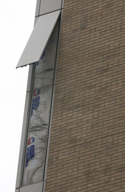 A piece of siding has fallen off the new police station on Garry St in downtown Winnipeg Thursday near noon-Another piece is dangling causing Police to block Garry St until repairs can be done-Breaking News- Jan 22, 2015   (JOE BRYKSA / WINNIPEG FREE PRESS)