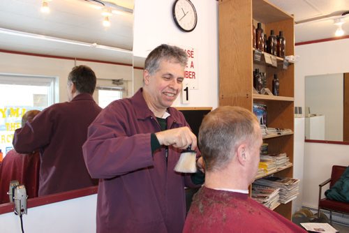 Grant Hurrell, aka Hymie the Haircutter, of Neepawa gives a customer a trim. Hurrell is a volunteer RCMP constable on weekends. BILL REDEKOP/WINNIPEG FREE PRESS Jan 21, 2015