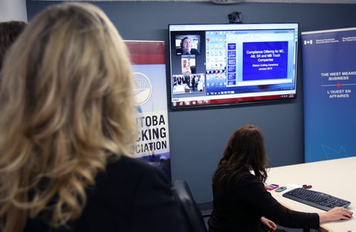 Shelly Glover- Minister of Canadian Heritage and Official Languages, left, and Gary Arnold of the Manitoba Trucking Association (MTA)  watch high tech video conferencing at news conference where $268,000 in funding was announced to provide Western Canadian truck drivers and managers with skills training and technology demonstrations -See Mia Rabson story- Jan 23, 2015   (JOE BRYKSA / WINNIPEG FREE PRESS)