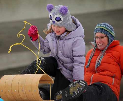 Gabrielle Ainslie who will be turning seven next month, gets ready to toboggan down the hill along the train tracks on Wellington Cres. Saturday with her mom, Martha.   Jan 24, 2015 Ruth Bonneville / Winnipeg Free Press
