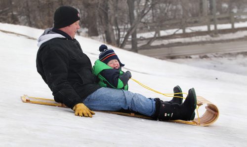 Two-year-old Jaxon Winters  closes his eyes as he slides down the hill next to the train tracks on Wellington Cres. Saturday with his dad, Ben Winters.  Jan 24, 2015 Ruth Bonneville / Winnipeg Free Press