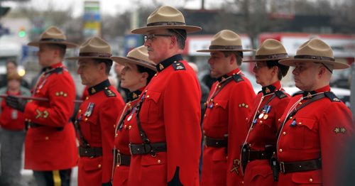 Superintendant Marlon Dawaskiba (4th from left) stands at attention with An RCMP Honor Guard in front of the Portage ave "D" Division's Winnipeg HQ to lay a wreath in memorium of Cst David Wyn, who was shot and killed in Alberta last week. See story. January 26, 2015 - (Phil Hossack / Winnipeg Free Press)