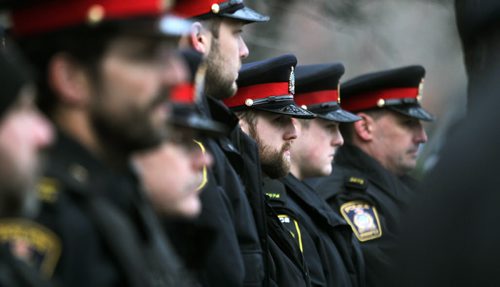 A sombre troup or Winnipeg City Police stand at the Portage ave "D" Division's Winnipeg HQ as a wreath was layed in memorium of Cst David Wyn, who was shot and killed in Alberta last week. See story. January 26, 2015 - (Phil Hossack / Winnipeg Free Press)