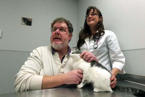 PET PAGE - The trials and tribulations of getting a pet cat to swallow a pill. (L) Humane Society veterinarian Dr. Erika M. Anseeuw with(R) WFP's Doug Speirs "pilling" a cat. Pilling is administering drugs to a cat in the form of a pill. BORIS MINKEVICH / WINNIPEG FREE PRESS  Jan. 27, 2015