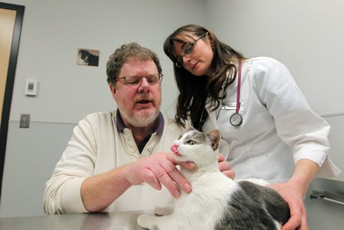PET PAGE - The trials and tribulations of getting a pet cat to swallow a pill. (R) Humane Society veterinarian Dr. Erika M. Anseeuw with(L) WFP's Doug Speirs "pilling" a cat. Pilling is administering drugs to a cat in the form of a pill. BORIS MINKEVICH / WINNIPEG FREE PRESS  Jan. 27, 2015