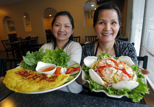 RESTAURANT REVIEW - Pho Binh Minh at 819 Sargent Ave. In photo (L) Stacy Kha with her mother (R) Ca Huynh holding dishes (L)Banh Xeo and (R)Green Mango Chicken/Shrimp. BORIS MINKEVICH / WINNIPEG FREE PRESS  Jan. 27, 2015