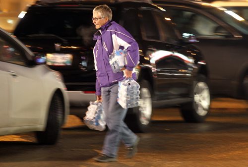 Shoppers leave a St Boniface retail outlet after stocking up with bottled water Tuesday evening after the city was put under a boil water advisory. See story. January 27, 2015 - (Phil Hossack / Winnipeg Free Press)