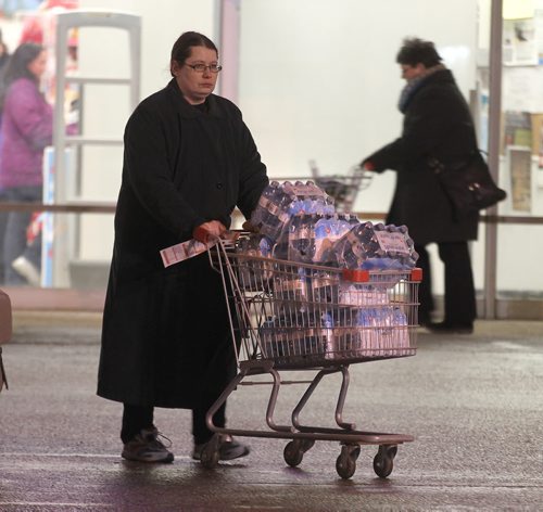 Shoppers leave a St Boniface retail outlet after stocking up with bottled water Tuesday evening after the city was put under a boil water advisory. See story. January 27, 2015 - (Phil Hossack / Winnipeg Free Press)