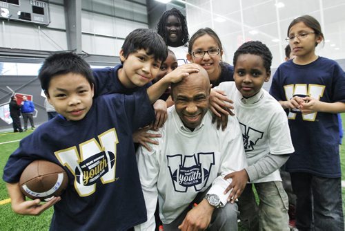 Dave Donaldson, Founder Inner City Flag Football league, is mobbed by kids after the announcement that the UofW and the Winnipeg Blue Bombers were going to team up with his organization to offer free winter football programs that will support WinnipegÄôs inner city youth with fundamental skill development, off-season conditioning, and flag football training. 150128 January 28, 2015 Mike Deal / Winnipeg Free Press