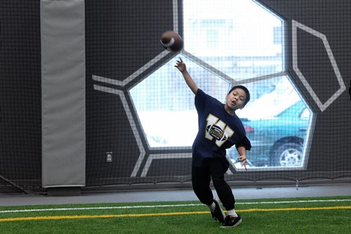 Dahler Htoo, 9, plays catch after the announcement that the Inner City Flag Football league, the UofW and the Winnipeg Blue Bombers were going to team up to offer free winter football programs that will support WinnipegÄôs inner city youth with fundamental skill development, off-season conditioning, and flag football training. 150128 January 28, 2015 Mike Deal / Winnipeg Free Press