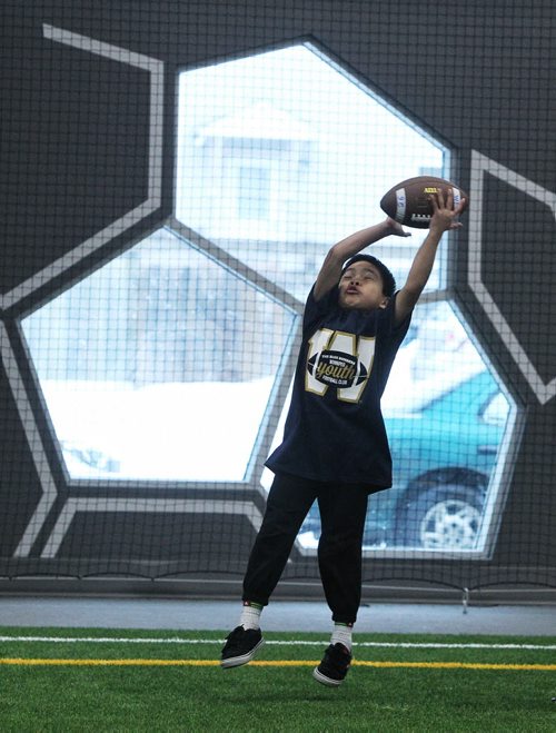 Dahler Htoo, 9, plays catch after the announcement that the Inner City Flag Football league, the UofW and the Winnipeg Blue Bombers were going to team up to offer free winter football programs that will support WinnipegÄôs inner city youth with fundamental skill development, off-season conditioning, and flag football training. 150128 January 28, 2015 Mike Deal / Winnipeg Free Press