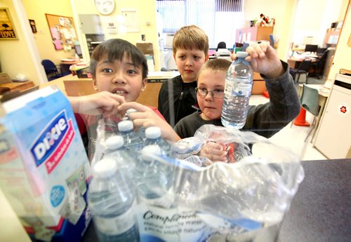 Victory School students Adlai Pascual (left), Max Balzer (centre) and Brendan Pirrie fetch water bottles from the school office to bring to kindergarden students in their gym class Wednesday afternoon due to the boil water advisory by the City of Wpg.  See story.   Jan 28, 2015 Ruth Bonneville / Winnipeg Free Press