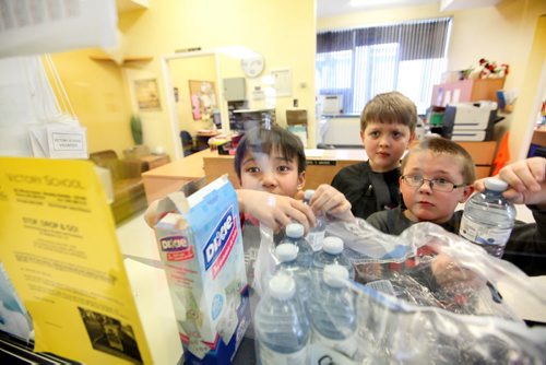 Victory School students Adlai Pascual (left), Max Balzer (centre) and Brendan Pirrie fetch water bottles from the school office to bring to kindergarden students in their gym class Wednesday afternoon due to the boil water advisory by the City of Wpg.  See story.   Jan 28, 2015 Ruth Bonneville / Winnipeg Free Press