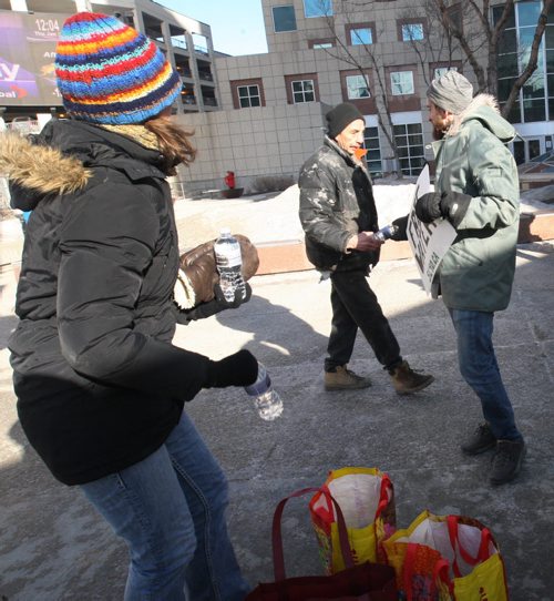 Chuck Wright, right, and a small group of concerned citizens handed out bottles of water with a statement on the labels to highlight the irony of a 17-Year Long Boil Water Advisory in Shoal Lake #40 the source of Winnipegs drinking water in Winnipeg Thursday near Portage and Main- Winnipeg has gone 1 1/2 days while the Shoal Lake First Nation has gone 6205 days  or 17 years on a boil order advisory. The band is seeking a all-season road to the community would make building a water treatment plant affordable-See Adam Wazny story- Jan 29, 2015   (JOE BRYKSA / WINNIPEG FREE PRESS)