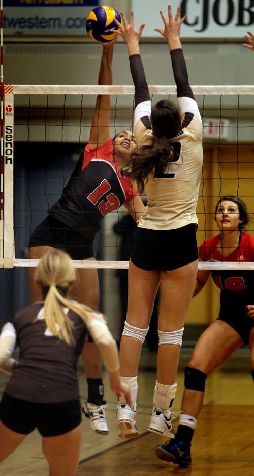 U of W Wesmen #13 Chelsea Jones hits past U of M Bison blocker #2 Kalena Schultz Thursday night as the Cross town rivals faved off at the Investor's Athletic Center on the U of M campus. January 29, 2015 - (Phil Hossack / Winnipeg Free Press)