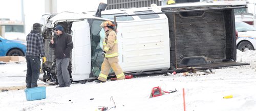 A Springfield firefighter and two men who may have been the occupants around the upended truck involved in a collision at Dugald Road and the Perimeter Hwy Friday morning. Apparently there was more than one vehicle involved this was the one remaining at 1030. January 30, 2015 - (Phil Hossack / Winnipeg Free Press)