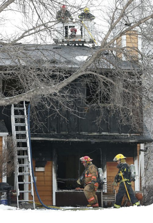 Winnipeg Fire Fighters at the scene of a townhouse fire at 1736 St. Mary's Rd. The fire was contained to one unit but it is a total lose. No one was in the unit when fire crews arrived, two cats and two dogs may have perished, they have not been found . Wayne Glowacki/Winnipeg Free Press Jan. 30 2015 ¤