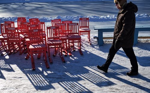 A pedestrian walks past a bunch of chairs equipped with skies for use on the River Trail Sunday morning.  150201 February 01, 2015 Mike Deal / Winnipeg Free Press