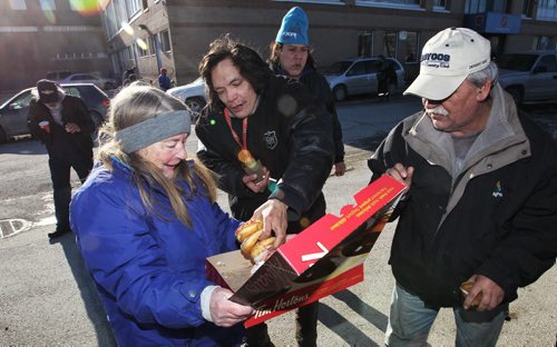 Marsha Eldridge holds up a box of doughnuts outside Booth Centre on Henry Avenue Sunday afternoon. Marsha and her husband Ron have been handing out hot drinks for those in need for years and today was no different, people were very happy to see them.  150201 February 01, 2015 Mike Deal / Winnipeg Free Press