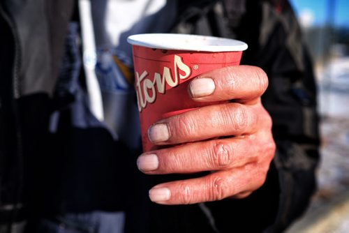 Rodger Charron holds a cup of hot chocolate that he got from Ron Eldridge outside Booth Centre on Henry Avenue Sunday afternoon. Ron Eldridge and his wife Marsha have been handing out hot drinks for those in need for years and today was no different, people were very happy to see them.  150201 February 01, 2015 Mike Deal / Winnipeg Free Press