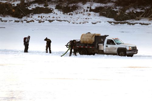 LOCAL STANDUP WEATHER - Crews work on the skating trail on the Red River near St. Mary's and St. Annes. The truck that floods the ice stops once in a while to drill a hole and refill their water tank. BORIS MINKEVICH / WINNIPEG FREE PRESS  FEB. 2, 2015