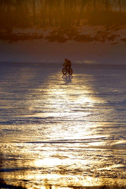 LOCAL STANDUP WEATHER - A Bicyclist rides down the Red River near St. Mary's and St. Annes. BORIS MINKEVICH / WINNIPEG FREE PRESS  FEB. 2, 2015