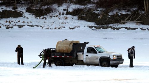 LOCAL STANDUP WEATHER - Crews work on the skating trail on the Red River near St. Mary's and St. Annes. The truck that floods the ice stops once in a while to drill a hole and refill their water tank. BORIS MINKEVICH / WINNIPEG FREE PRESS  FEB. 2, 2015