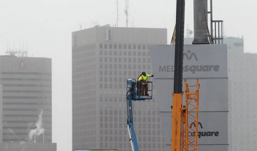 A new high-rise sign for Medosquare that overlooks downtown Winnipeg gets put into place by workers on Sutherland Ave. Tuesday afternoon.   Standup photo  Feb 03, 2015 Ruth Bonneville / Winnipeg Free Press