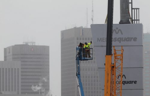 A new high-rise sign for Medosquare that overlooks downtown Winnipeg gets put into place by workers on Sutherland Ave. Tuesday afternoon.   Standup photo  Feb 03, 2015 Ruth Bonneville / Winnipeg Free Press