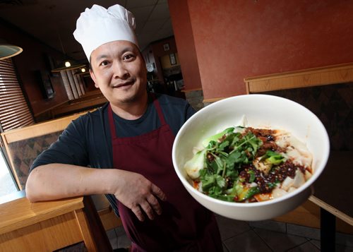 Jun Yang, co-owner and chef at the Golden Loong shows off the finished "hot spicy pork with hand-ripped noodles". See Marion Warhaft's review. February 3, 2015 - (Phil Hossack / Winnipeg Free Press)